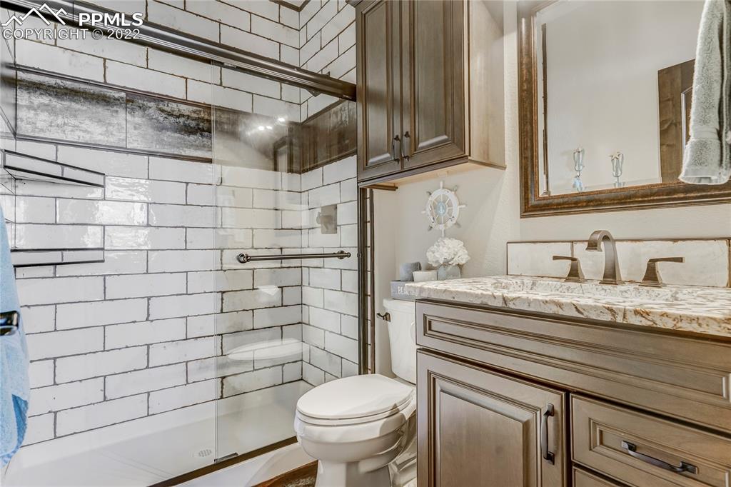 14325 Evans Road Elbert, CO 80106 - Photo 37 of 49 a bathroom with a granite countertop toilet sink and mirror