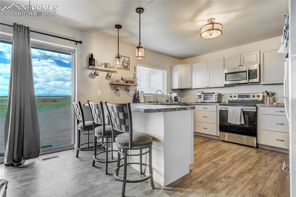 14325 Evans Road Elbert, CO 80106 - Photo 44 of 49 a kitchen with kitchen island a stove a table and chairs in it