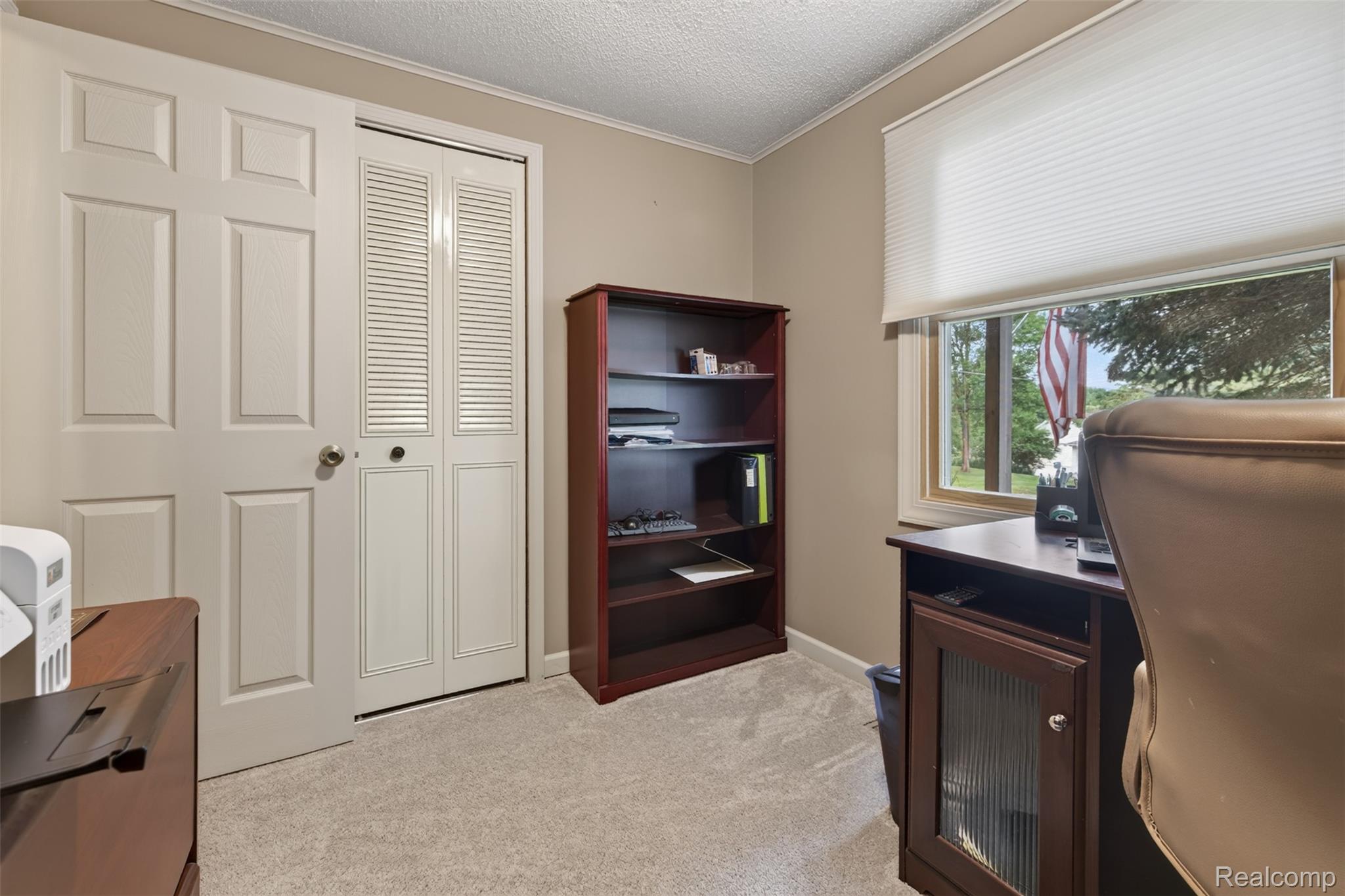 5977 Anglers Road Ortonville, MI 48462 - Photo 17 of 63 Carpeted room featuring a window with cellular shades, a swing door, and a bi-fold louvered door