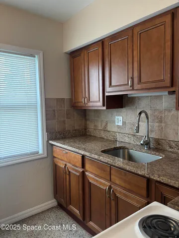 a kitchen with stainless steel appliances granite countertop a sink stove and cabinets