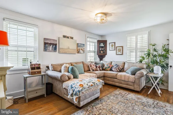 a living room with furniture wooden floor and a large window