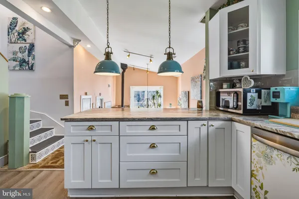 a kitchen with stainless steel appliances granite countertop a sink a stove and a wooden floors