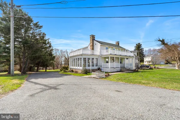 a view of a house with a big yard and large trees