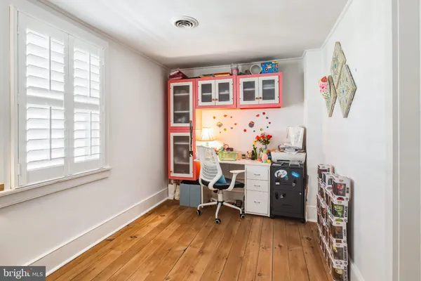 a view of a workspace with furniture and a window