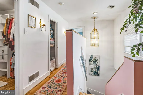 a view of a hallway with furniture and a potted plant