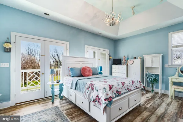 a bedroom with a bed chandelier and a window