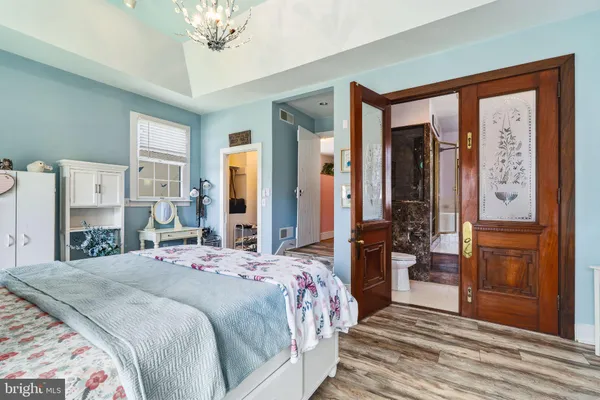 a bedroom with a bed and a chandelier