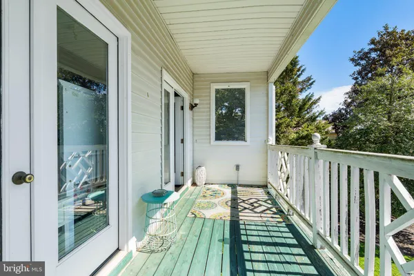a balcony with wooden floor table and chairs