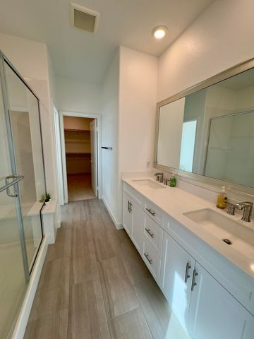 a spacious bathroom with a double vanity sink and a mirror