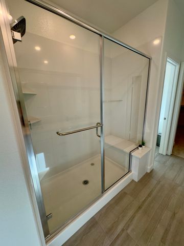 a bathroom with a glass door shower and toilet