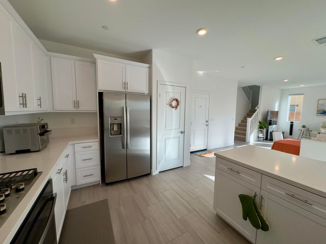 a kitchen with kitchen island white cabinets and stainless steel appliances