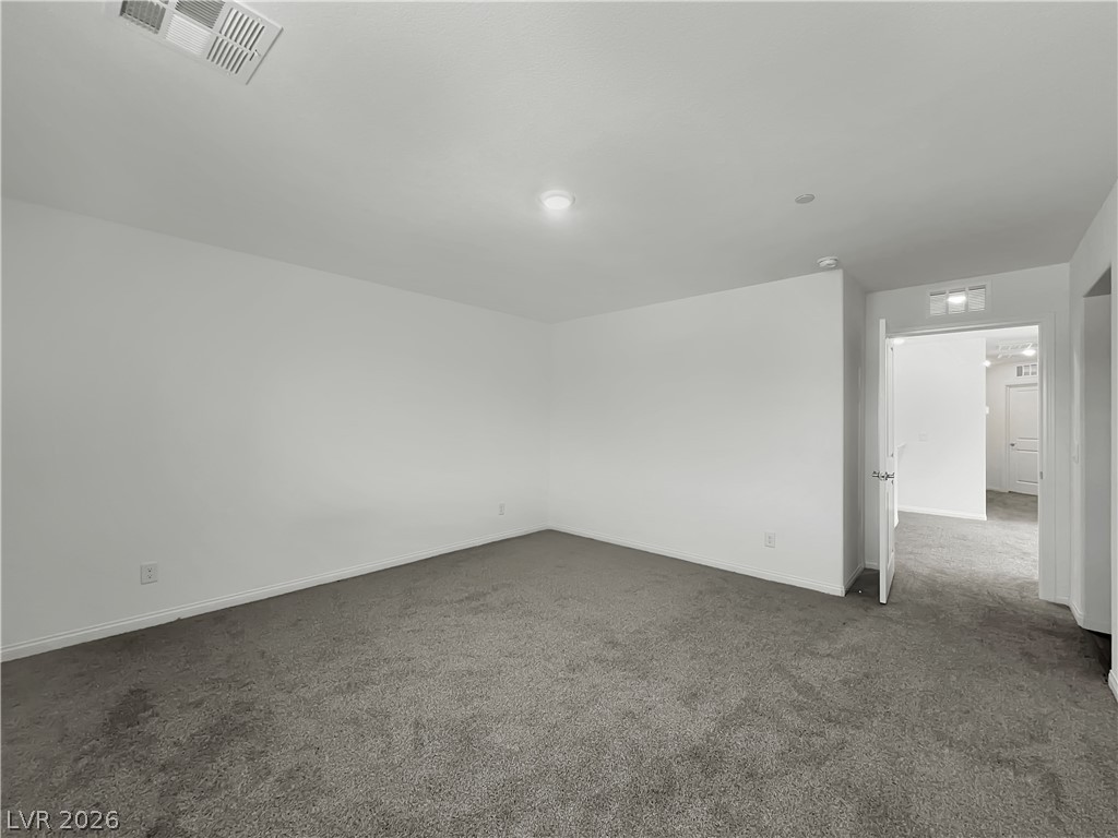 9984 Indigo Cliffs Street Las Vegas, NV 89141 - Photo 14 of 31 Spare room with visible vents, baseboards, and dark carpet