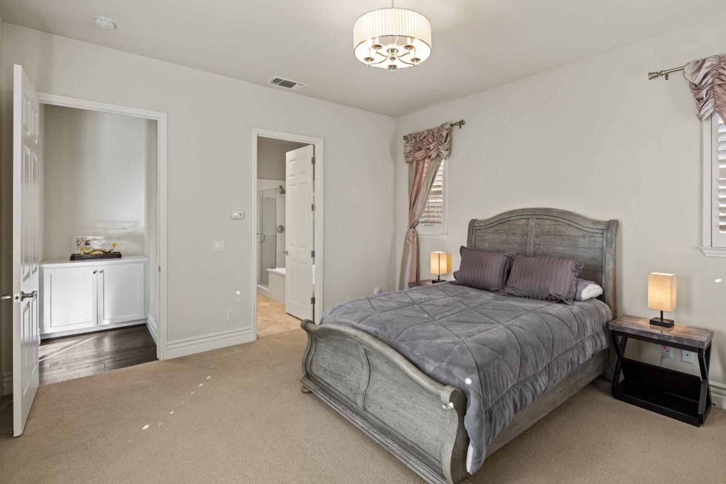 18511 McClellan Circle East Garrison, CA 93933 - Photo 27 of 65 a spacious bedroom with a bed and a chandelier