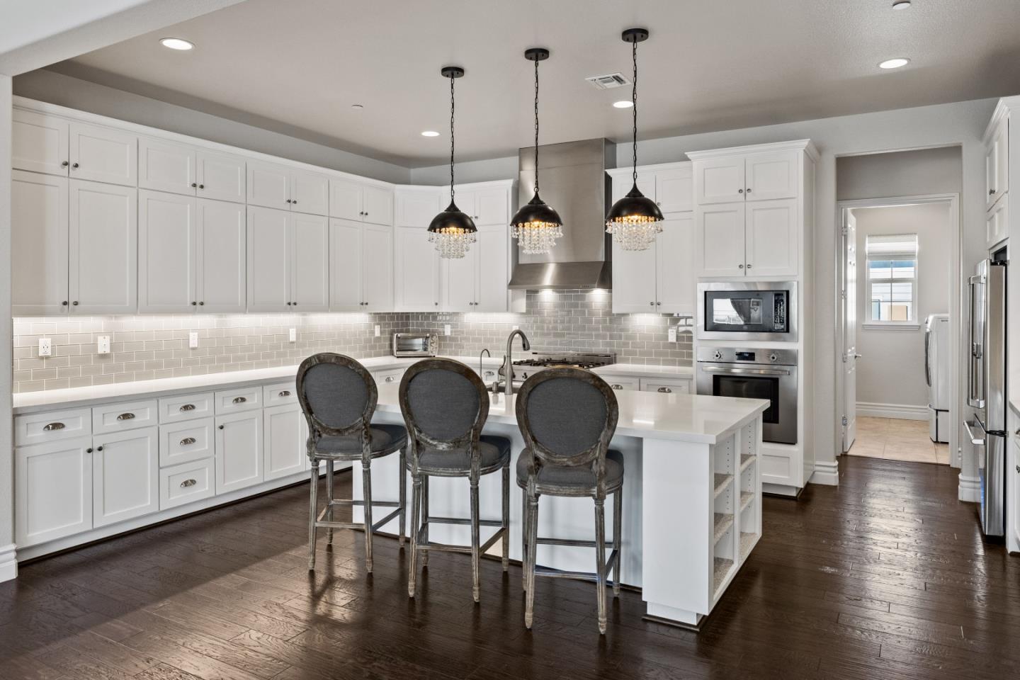 18511 McClellan Circle East Garrison, CA 93933 - Photo 10 of 65 a kitchen with cabinets wooden floor dining table and stainless steel appliances