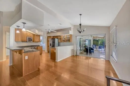 a view of a kitchen with dining area a sink wooden floor and chandelier