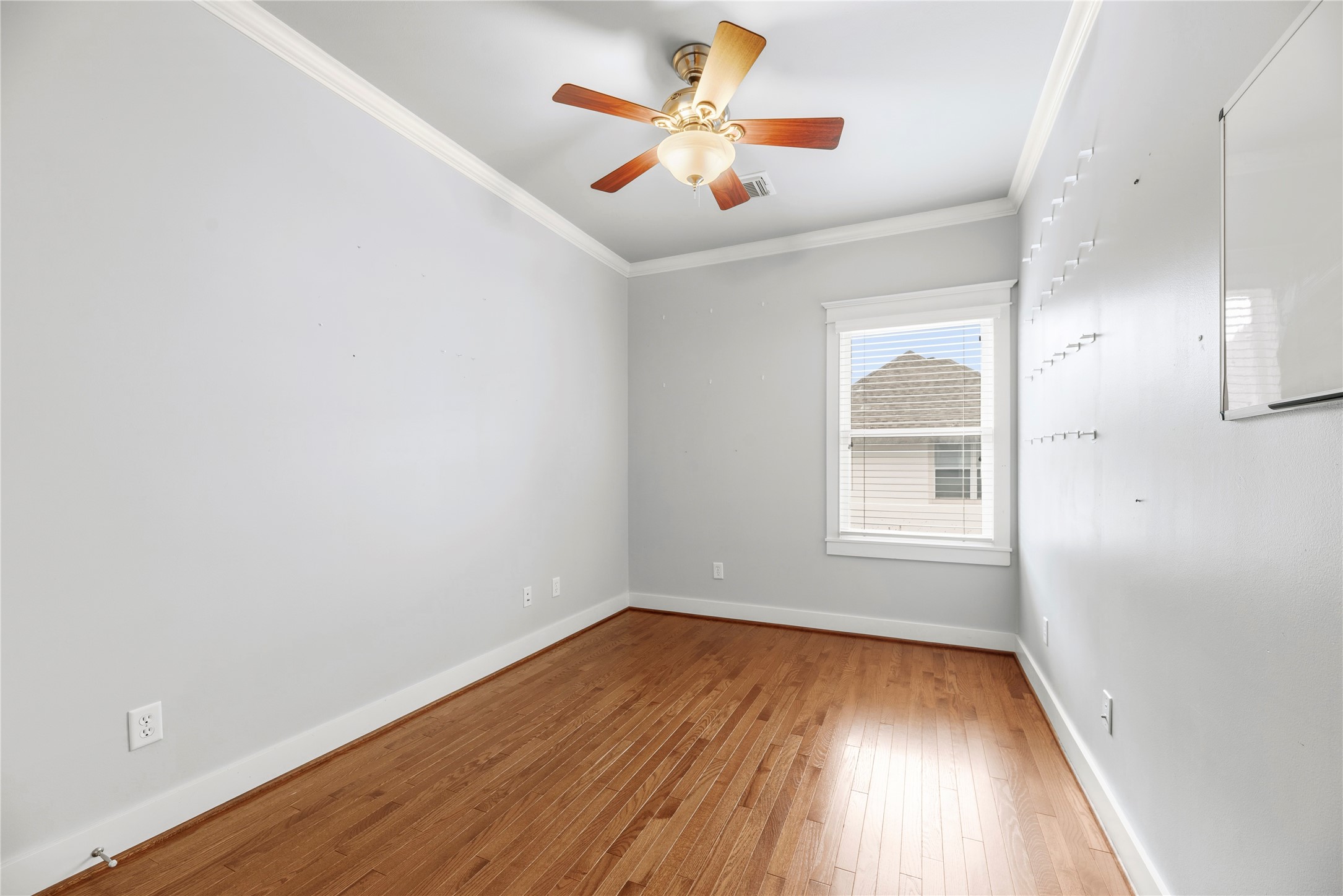 1505 Prince Street Houston, TX 77008 - Photo 27 of 39 Additional secondary bedroom, formerly utilized as an office, features wood floors, a bright window, and crown molding.