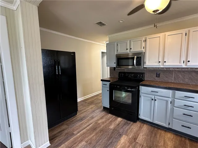 a kitchen with white cabinets and appliances