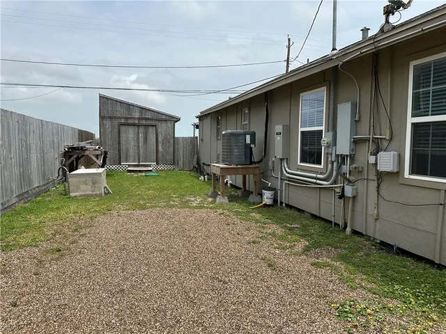 a backyard of a house with wooden fence and a bench