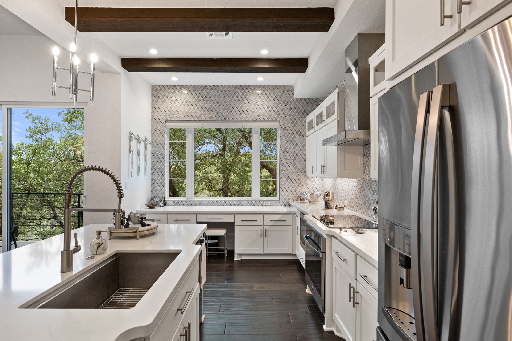 408 Rose Branch Way, Unit 24 Austin, TX 78738 - Photo 13 of 39 Kitchen with appliances with stainless steel finishes, white cabinets, pendant lighting, glass insert cabinets, and light stone countertops