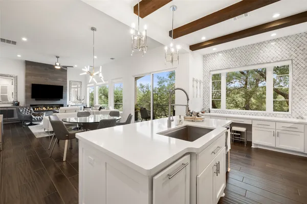 a large white kitchen with a large window and stainless steel appliances