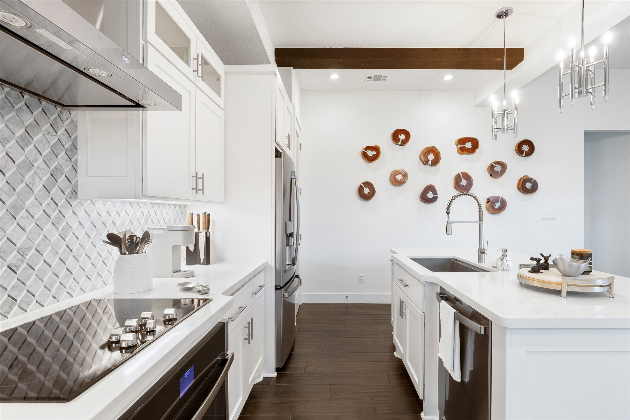 408 Rose Branch Way, Unit 24 Austin, TX 78738 - Photo 15 of 39 Kitchen featuring extractor fan, appliances with stainless steel finishes, beamed ceiling, decorative light fixtures, and white cabinets