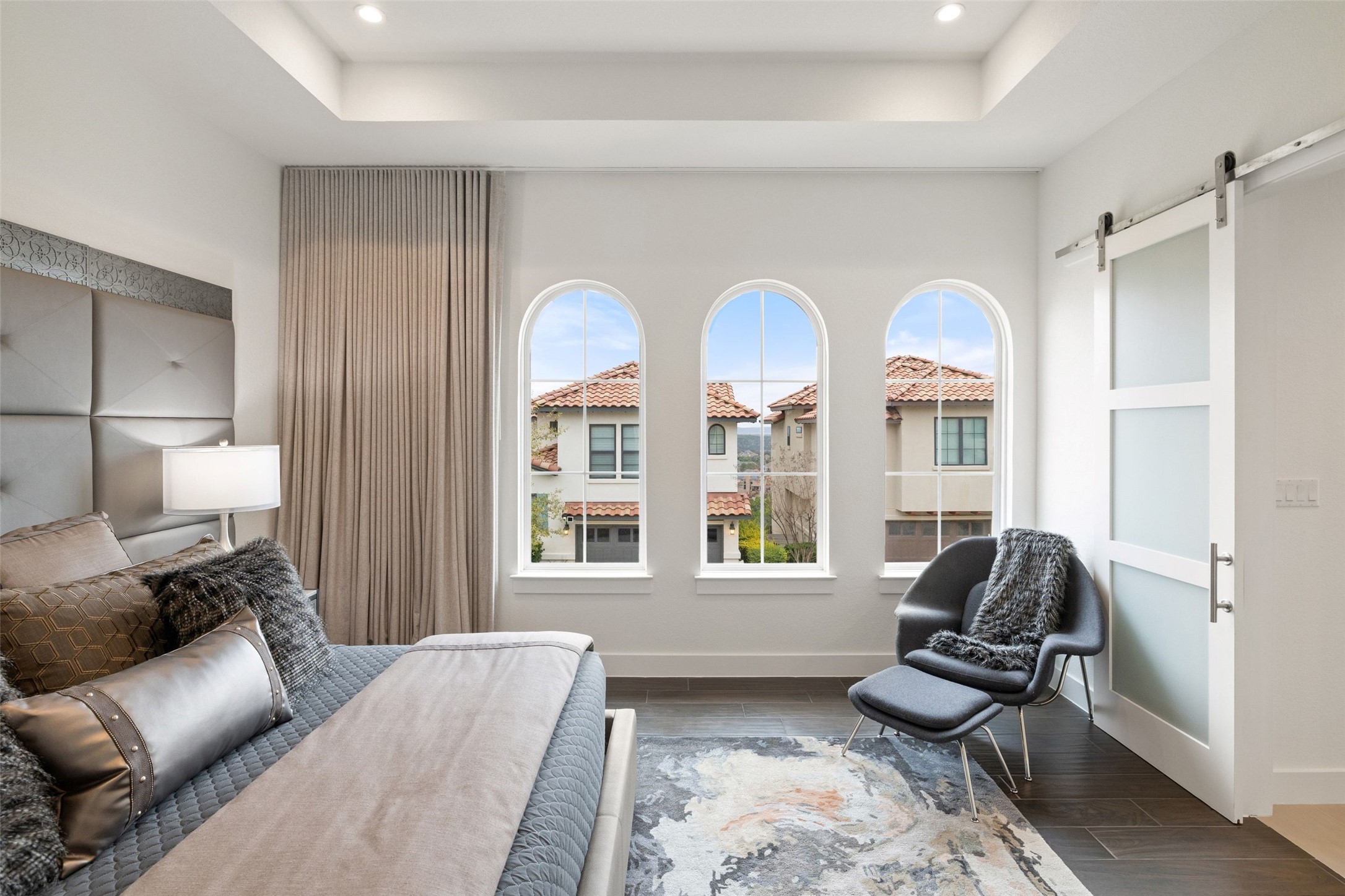 408 Rose Branch Way, Unit 24 Austin, TX 78738 - Photo 23 of 39 Bedroom featuring a barn door, wood finish floors, a tray ceiling, and recessed lighting