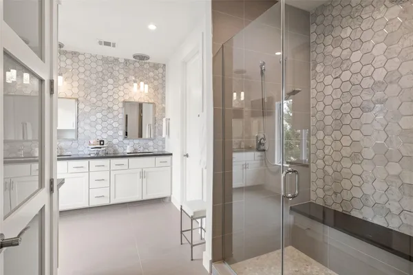 a bathroom with a granite countertop sink mirror and a shower