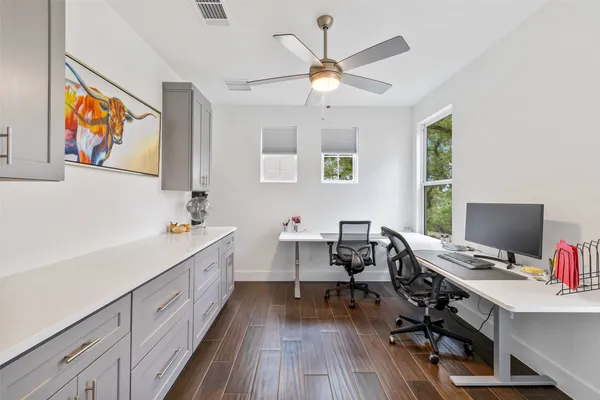 a view of a workspace with furniture and a window