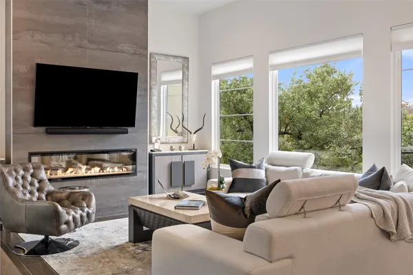 a living room with furniture a flat screen tv and a large window