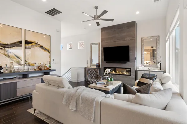 a living room with furniture a flat screen tv and a large window