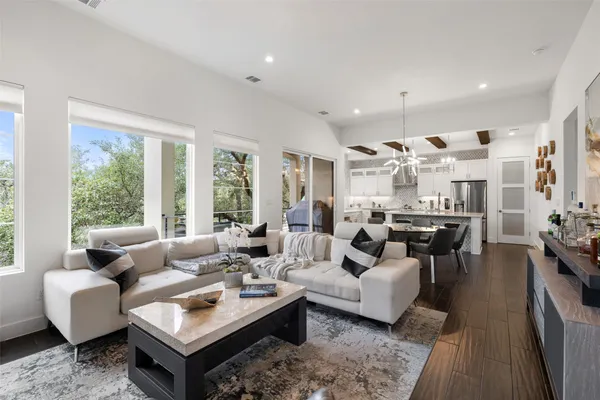 a living room with furniture wooden floor and a large window