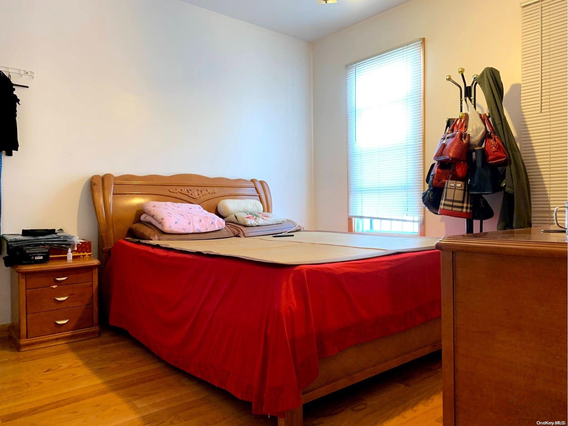 108-13 37th Avenue Queens, NY 11368 - Photo 3 of 23 a bed sitting in a bedroom next to a window
