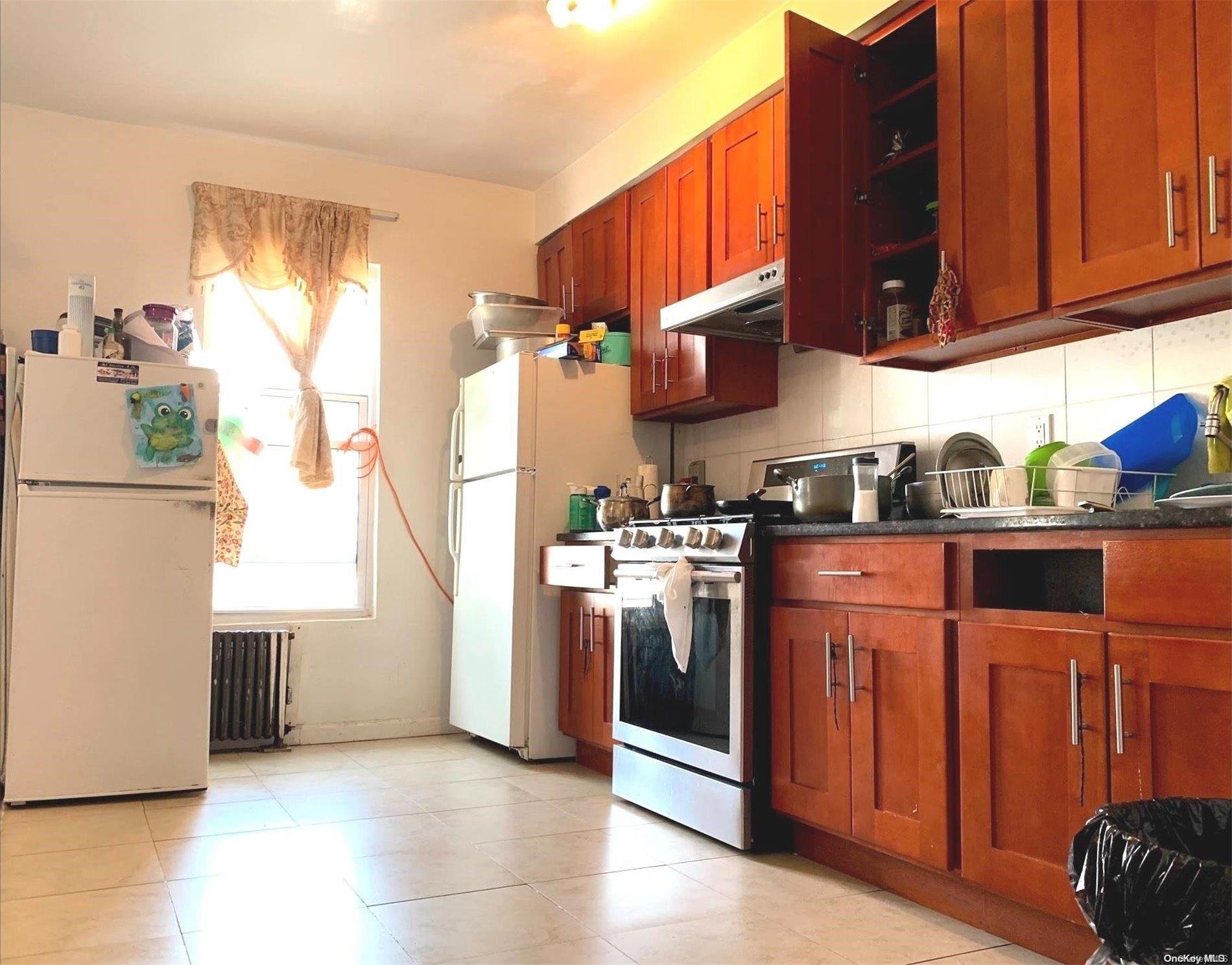 108-13 37th Avenue Queens, NY 11368 - Photo 7 of 23 a kitchen with stainless steel appliances granite countertop a refrigerator and a stove top oven