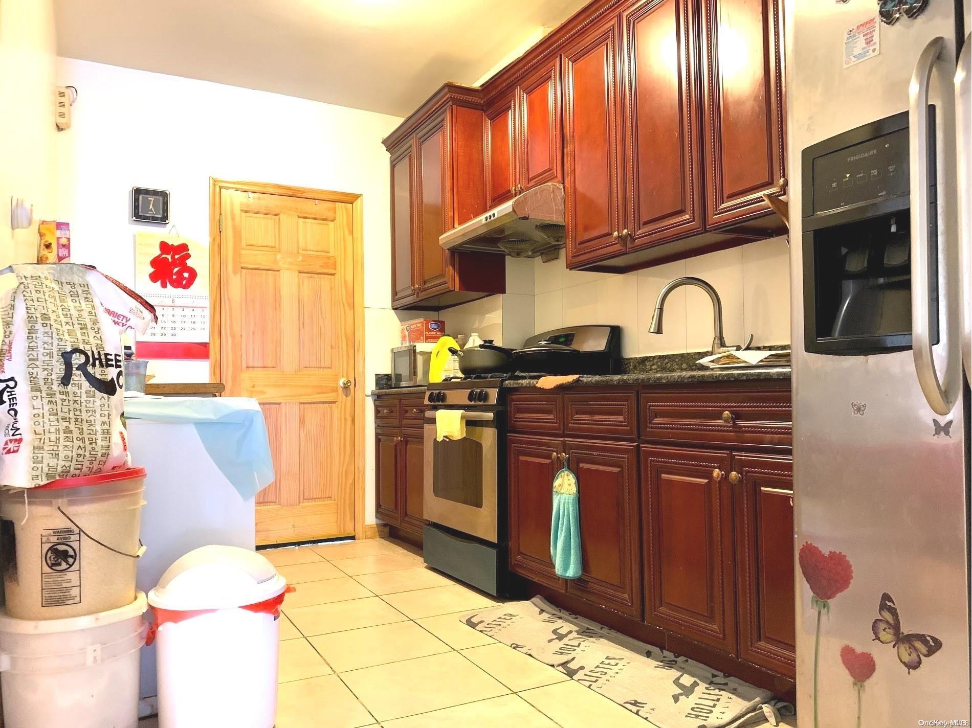 108-13 37th Avenue Queens, NY 11368 - Photo 8 of 23 a kitchen with granite countertop a stove a sink dishwasher and a microwave oven with cabinets