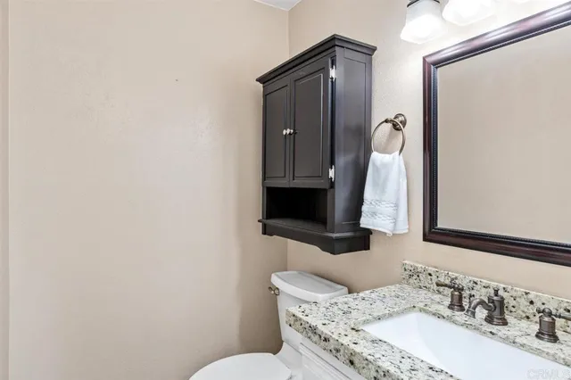 a kitchen with stainless steel appliances granite countertop a sink a stove a dining table and chair with wooden floor