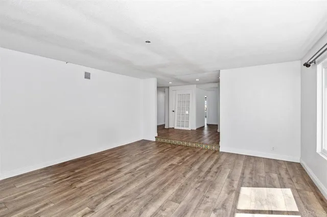 an empty room with a window and a ceiling fan