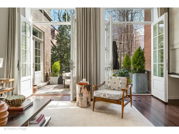 a kitchen with stainless steel appliances kitchen island granite countertop a dining table chairs and white cabinets