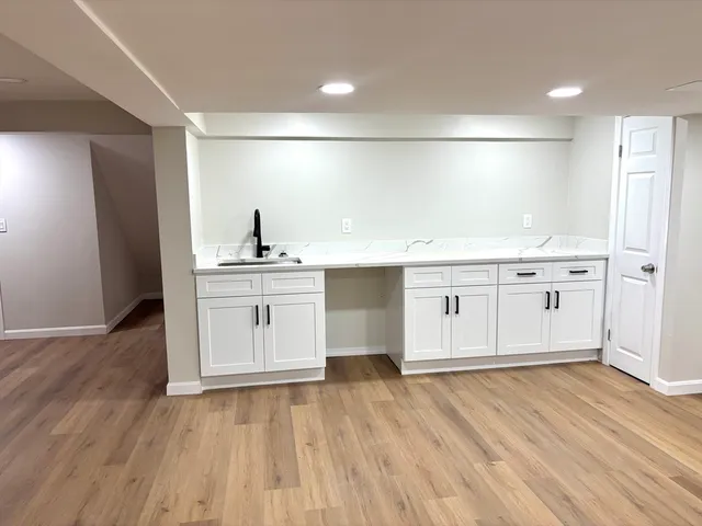 a kitchen with a sink cabinets and wooden floor