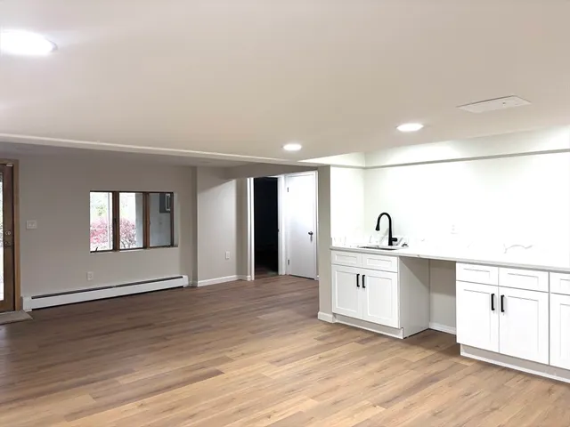 a large white kitchen with stainless steel appliances granite countertop a sink and cabinets