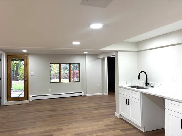 a kitchen with a sink cabinets and wooden floor