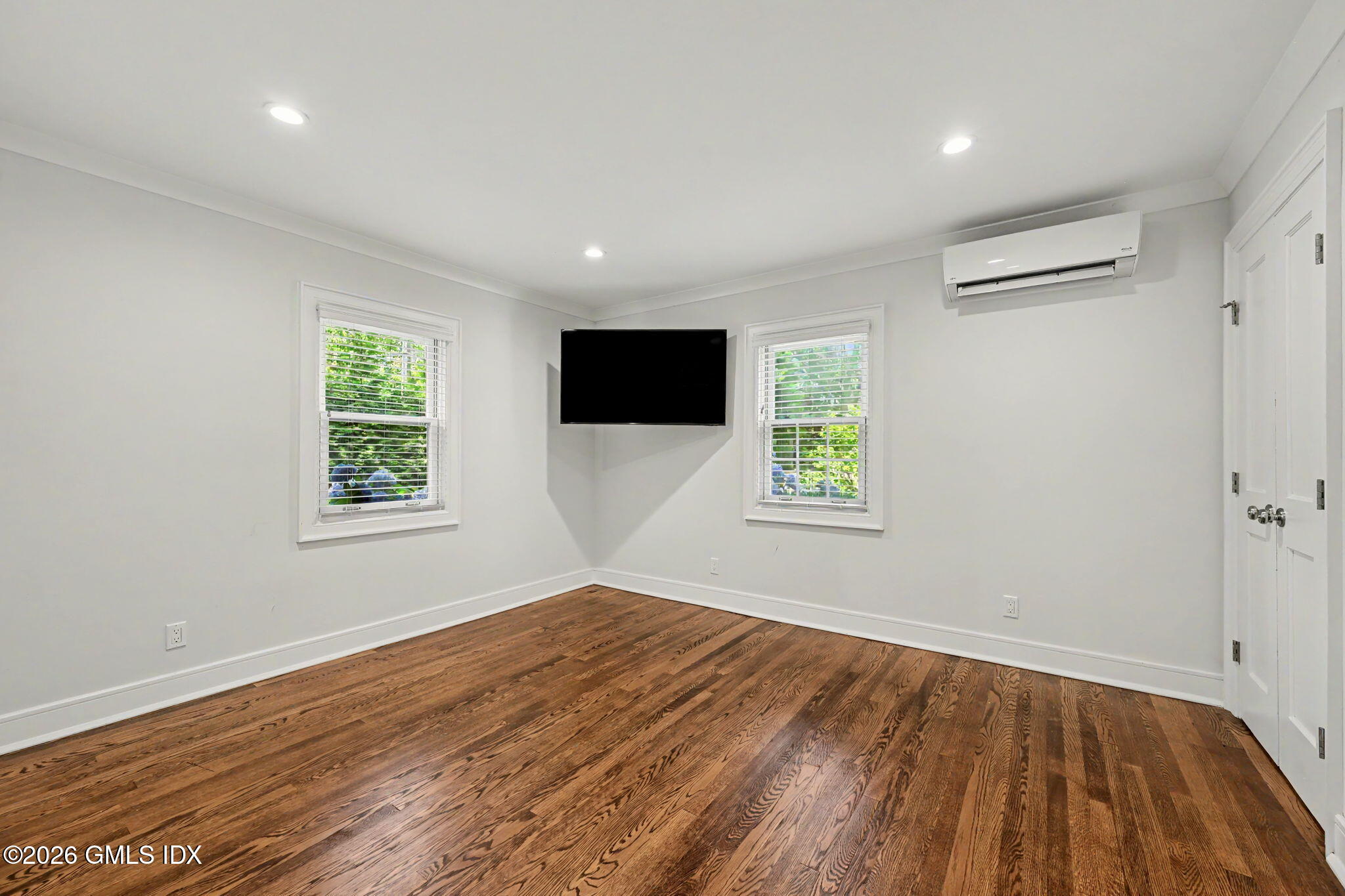 124 Shore Road Old Greenwich, CT 06870 - Photo 17 of 28 an empty room with wooden floor and windows