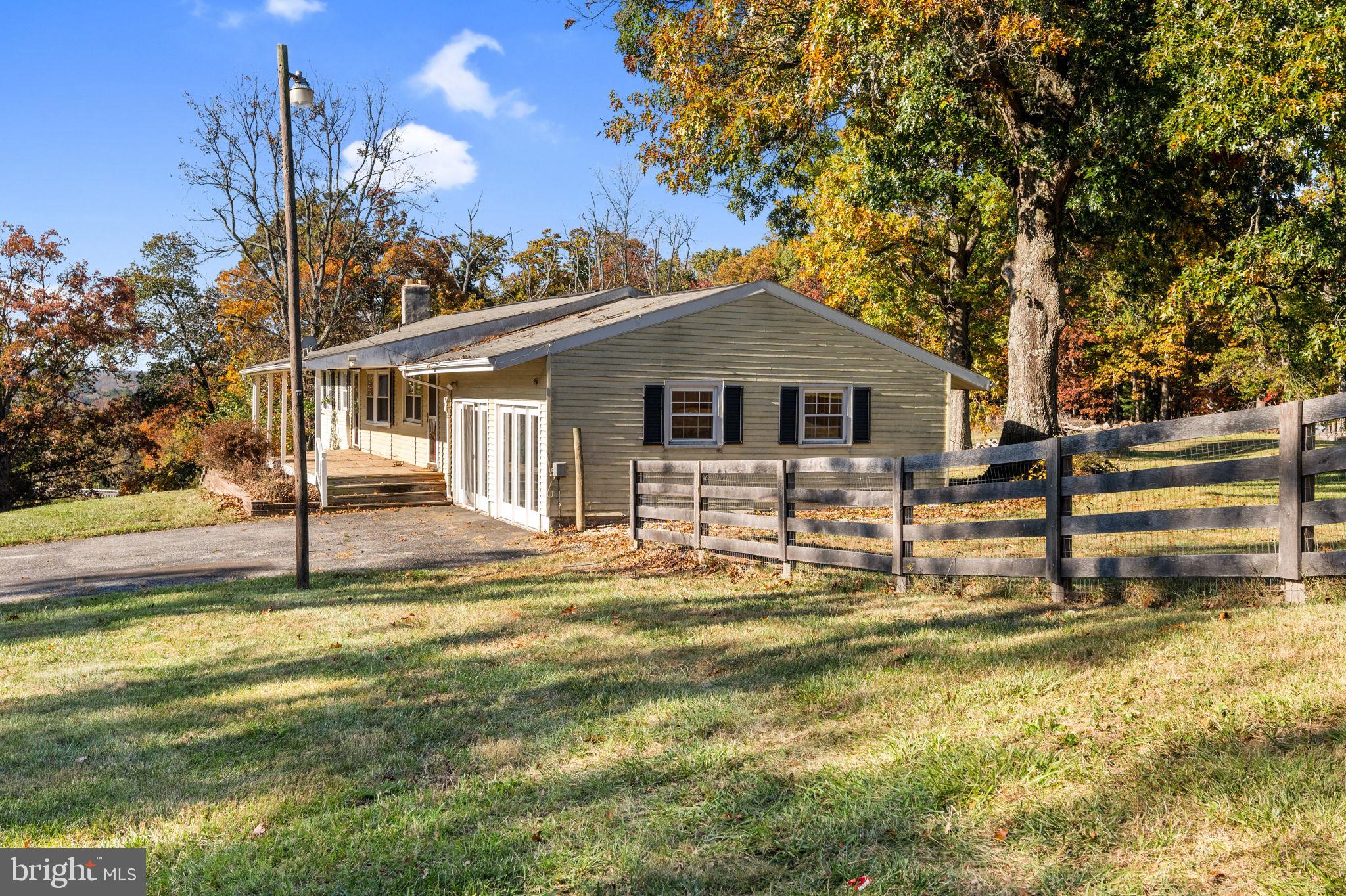3744 Back Woods Road Westminster, MD 21158 - Photo 11 of 62 a front view of a house with a yard table and chairs