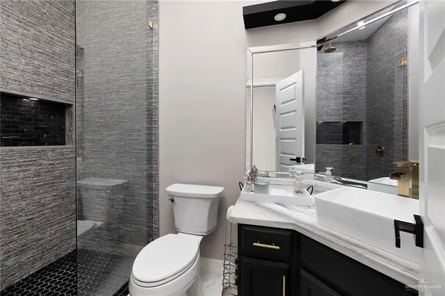 a bathroom with a sink a toilet and shower
