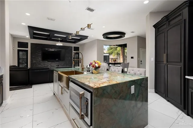 a kitchen with stainless steel appliances granite countertop a sink and a refrigerator