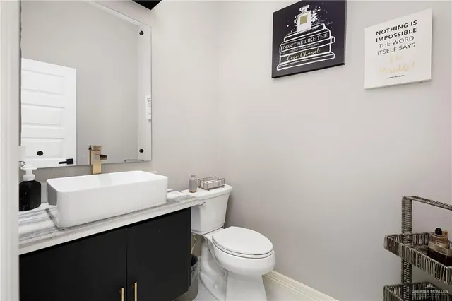a bathroom with a sink mirror vanity and toilet