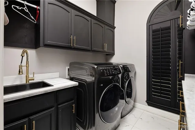 a utility room with sink dryer and washer