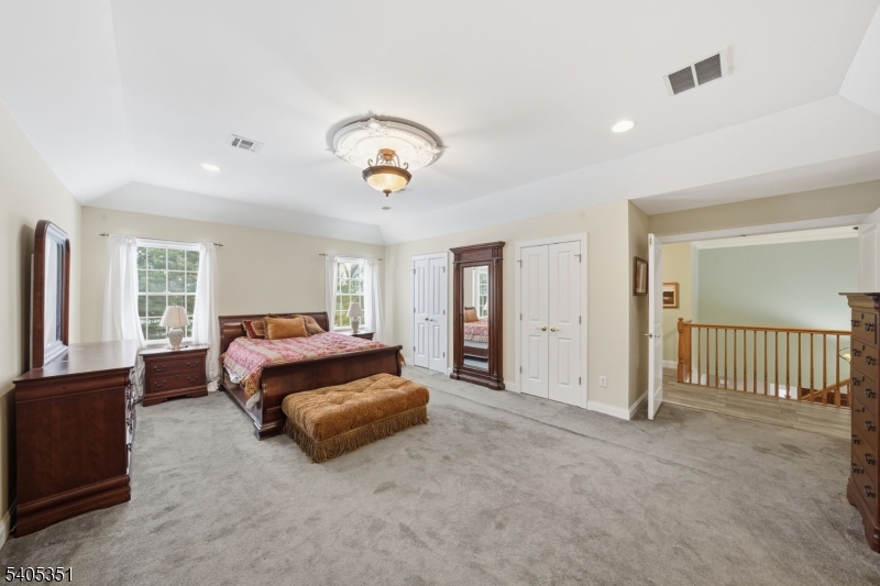 20 Sleepy Hollow Road Denville, NJ 07834 - Photo 27 of 49 a spacious bedroom with a bed and a chandelier
