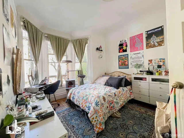 a bedroom with bed and large windows