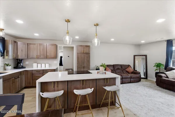 a kitchen with granite countertop a dining table chairs and white cabinets
