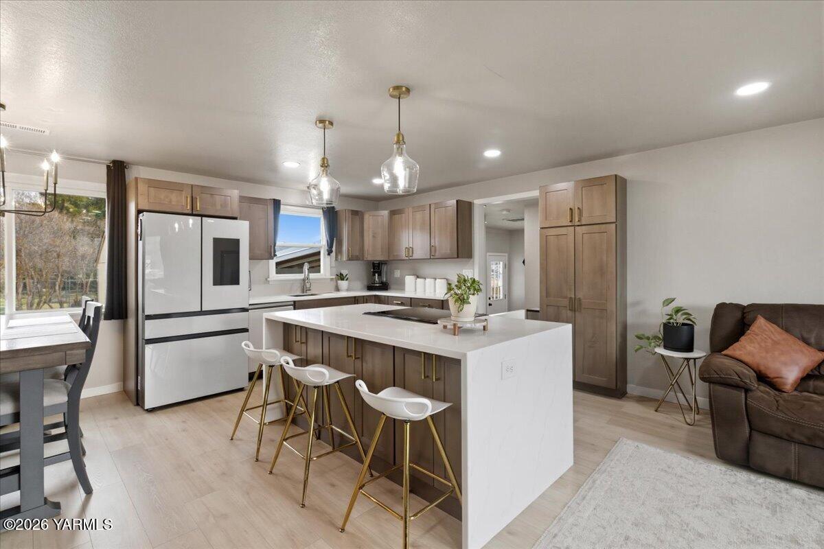 23 Shafer Avenue Naches, WA 98937 - Photo 5 of 29 a kitchen with a refrigerator a stove a sink dishwasher a dining table and chairs with wooden cabinets